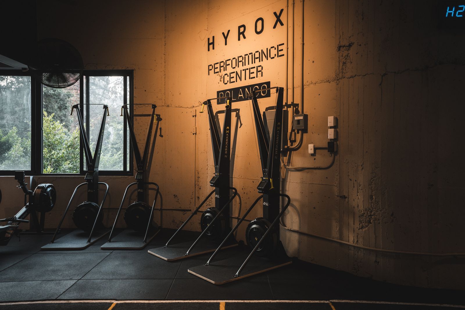Letrero del HYROX Performance Center con equipos de remo y ski